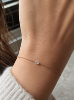 Load image into Gallery viewer,     Emerald-cut natural diamond bezel bracelet worn on a woman’s wrist.