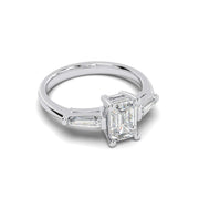 Angled front side view emerald cut lab-grown diamond ring with tapered side stones in white gold