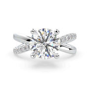     X-shank round natural diamond engagement ring in white gold with a pavé split band, front view on white background.