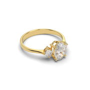 Three-stone oval lab-grown diamond ring in yellow gold shown from a side angle