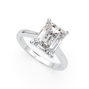 an emerald cut diamond ring on a white background