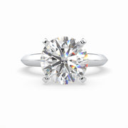 a round cut diamond ring on a white background
